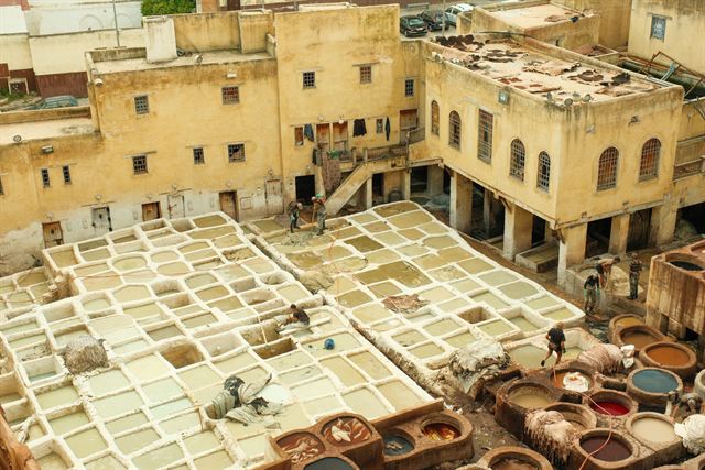 Chouara tannery in Fez seen from above, stone vats of dye and whitewash amid medina buildings
