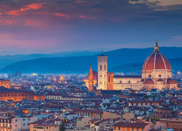 Florence skyline at dusk with the Duomo dome and Palazzo Vecchio tower above the old city