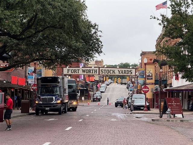 Historic Fort Worth Stockyards street with the Stock Yards gateway sign, brick storefronts and a truck