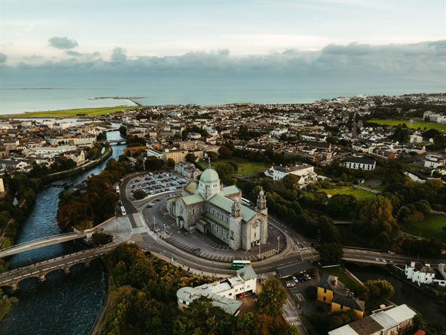 Aerial view of Galway with the green-domed cathedral beside the River Corrib and Galway Bay beyond