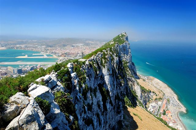 Aerial view along the limestone ridge of the Rock of Gibraltar above the town and sea