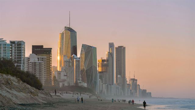 Surfers Paradise towers glowing at sunset above the Gold Coast beach and dunes
