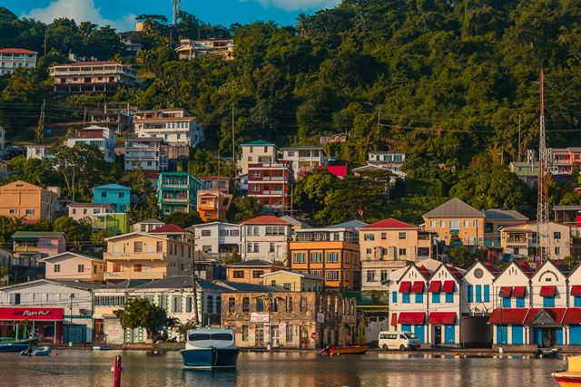 Colorful buildings stacked up the green hillside above the Carenage waterfront in St George's, Grenada