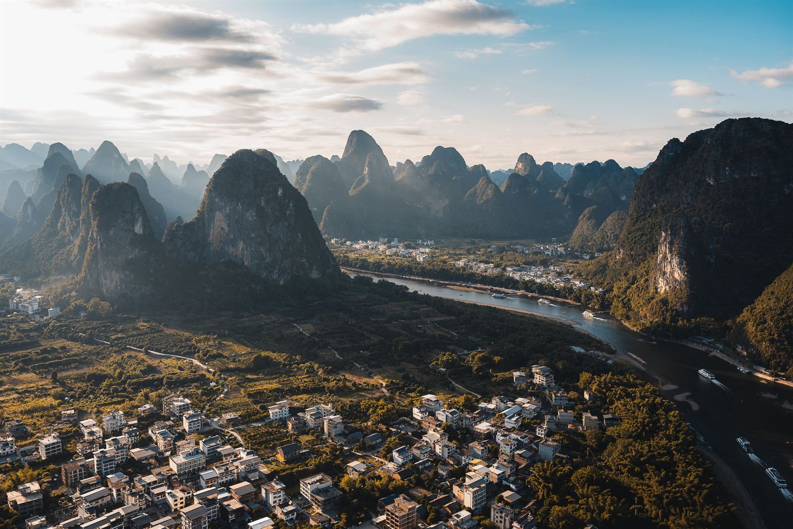 Aerial view of the Li River winding past a village among towering karst peaks near Guilin