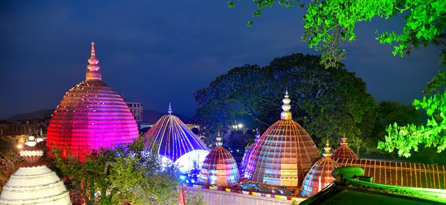 Kamakhya Temple domes lit in pink and purple at night on Nilachal Hill, Guwahati