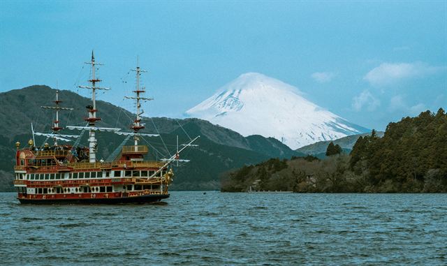 Replica pirate sightseeing ship cruising Lake Ashi in Hakone with snow-capped Mount Fuji behind
