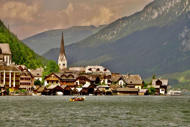 Hallstatt village with its Lutheran church spire on the shore of Hallstätter See below forested mountains