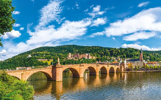 Old Bridge across the Neckar River leading to Heidelberg old town below the castle hillside