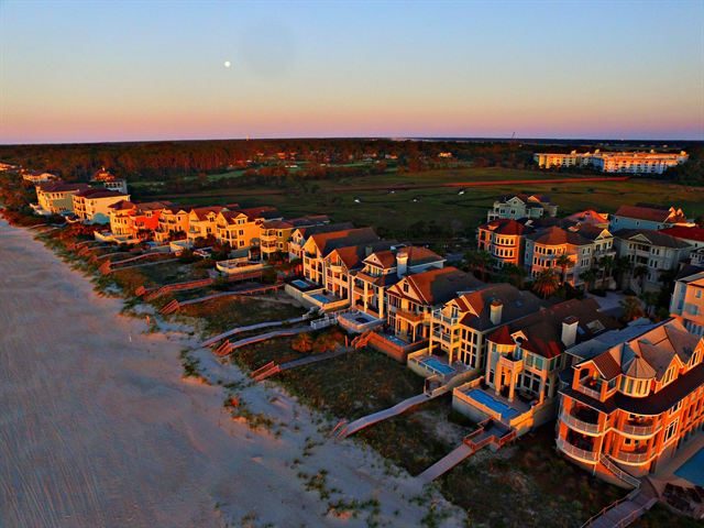 Aerial view of large oceanfront homes and dunes along the Hilton Head Island beach at sunset