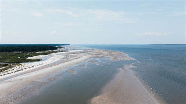 Aerial view of broad sandbars and tidal shallows along a Hilton Head Island beach