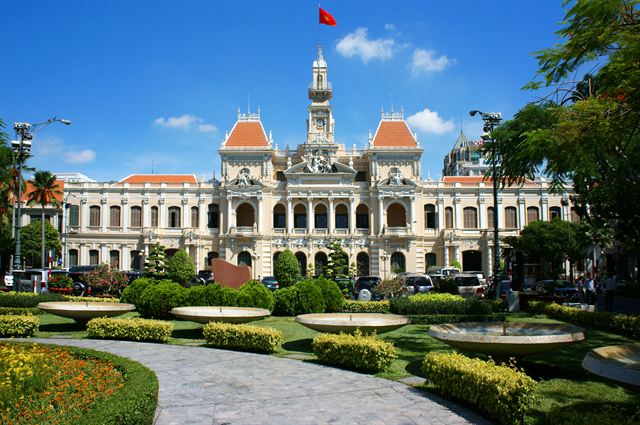 French colonial Ho Chi Minh City Hall with clock tower and formal gardens
