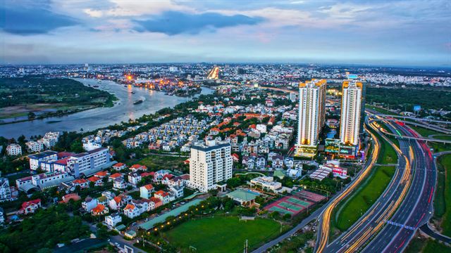 Aerial dusk panorama of Ho Chi Minh City towers, highways and the Saigon River