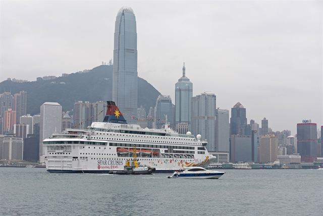 Cruise ship in Victoria Harbour with Hong Kong skyscrapers behind