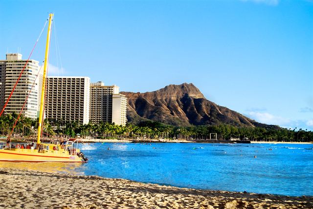 Catamaran on Waikiki Beach with hotels and Diamond Head behind