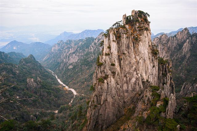 Pine-topped granite spire and deep valley at Huangshan, the Yellow Mountain
