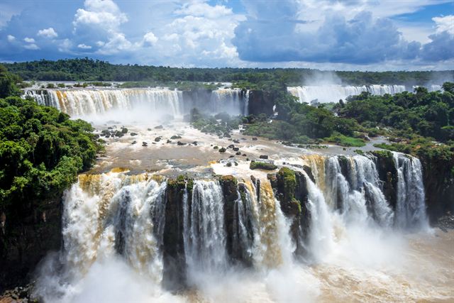 Wide curtain of Iguazu Falls cascading through tropical rainforest