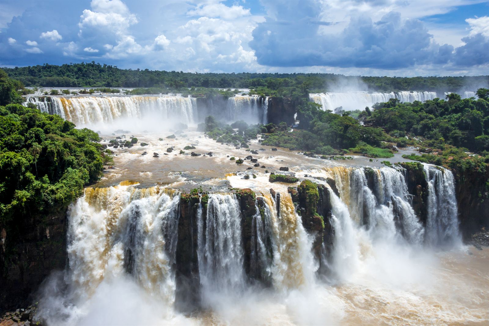 Wide curtain of Iguazu Falls cascading through tropical rainforest