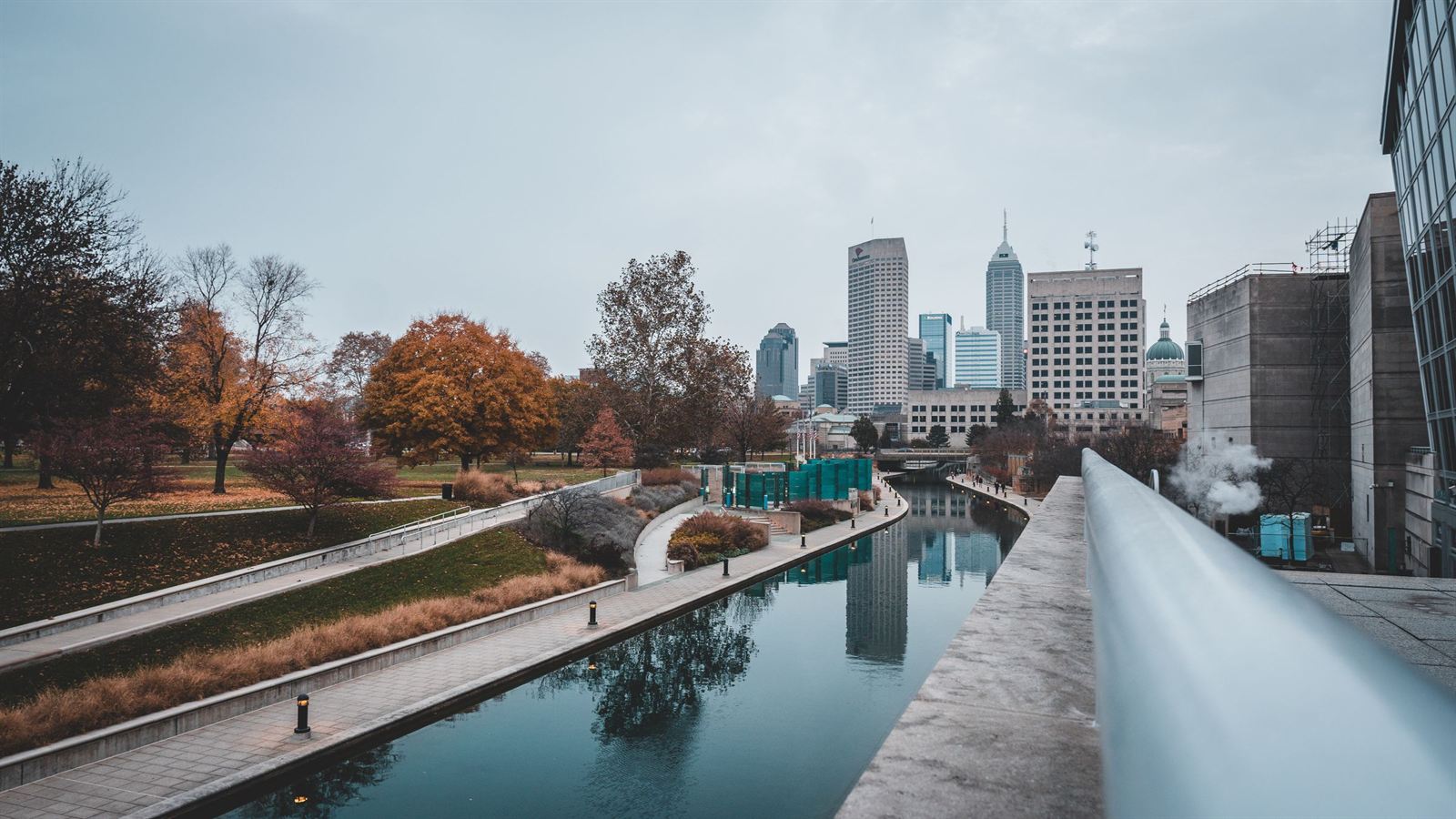 Indianapolis Central Canal walkway with autumn trees and the downtown skyline reflected in the water