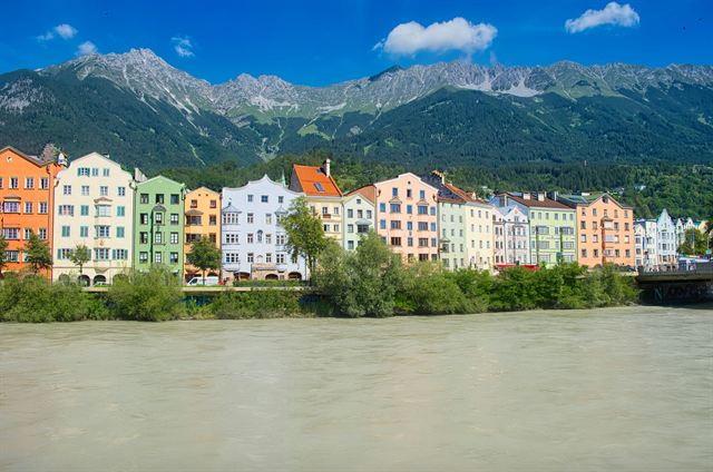 Row of colorful Mariahilf houses along the Inn River in Innsbruck under the Nordkette mountains