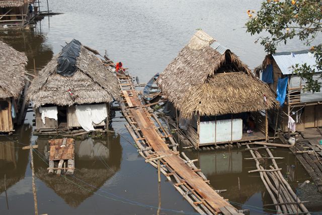 Thatched stilt houses and plank walkways over the Amazon river at Iquitos, Peru