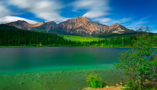 Pyramid Mountain rising above forest and the green waters of Patricia Lake in Jasper National Park