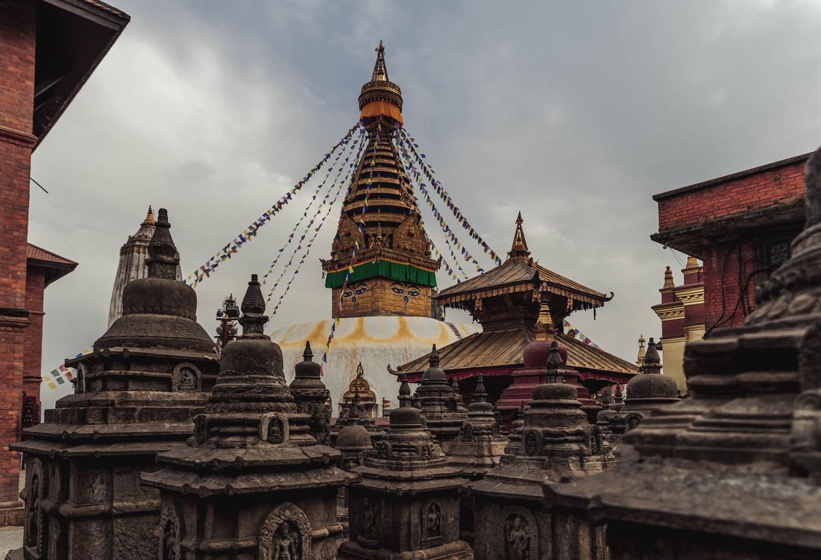 Swayambhunath Stupa in Kathmandu with its golden spire, painted eyes and prayer flags above shrines
