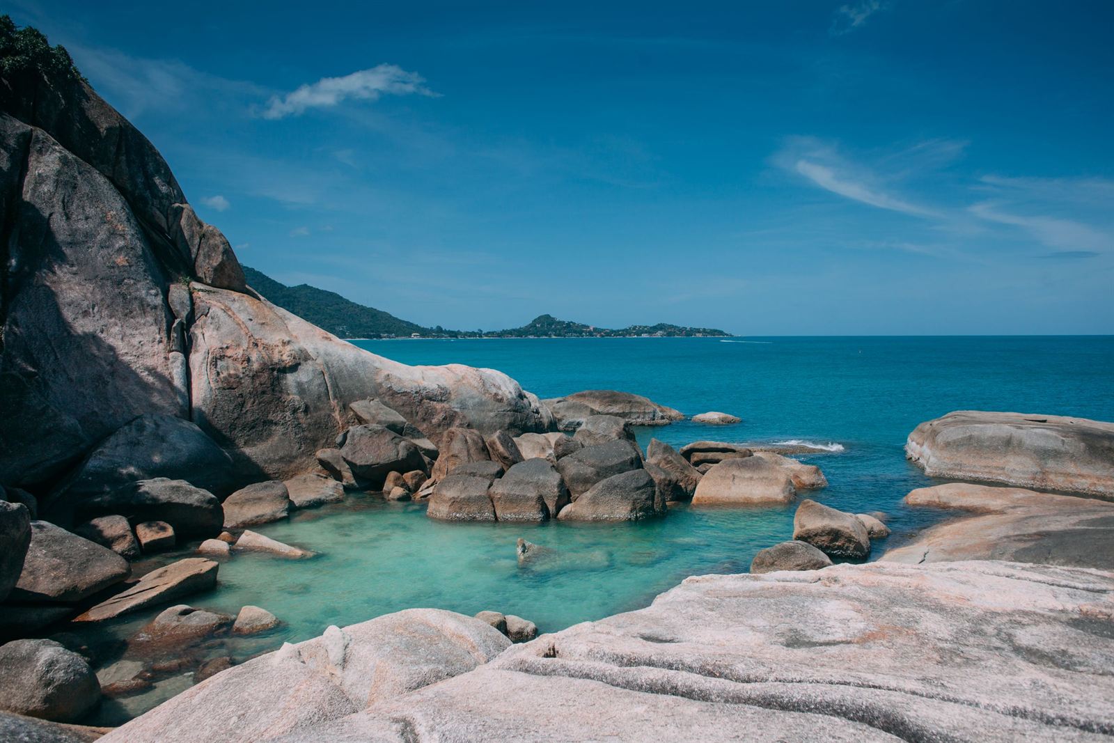 Rounded granite boulders enclosing a turquoise tidal pool on the Koh Samui coast, Thailand