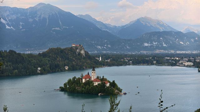 Lake Bled with Bled Island church and Bled Castle on its cliff, Julian Alps rising behind
