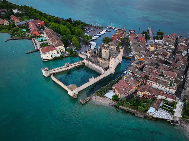 Aerial view of Sirmione on Lake Garda with the moated Scaliger Castle, harbor and turquoise water