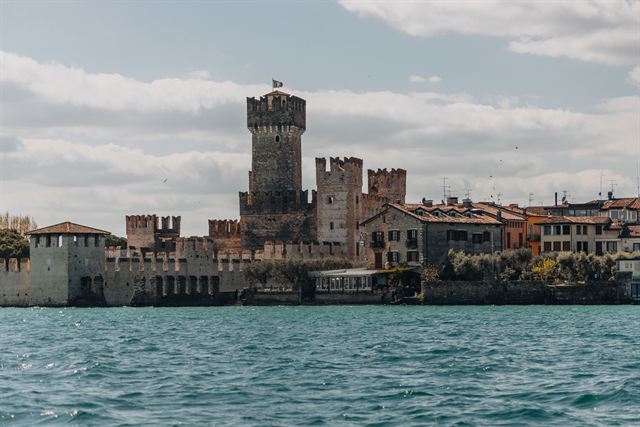 Scaliger Castle's crenellated towers and walls rising from Lake Garda at Sirmione