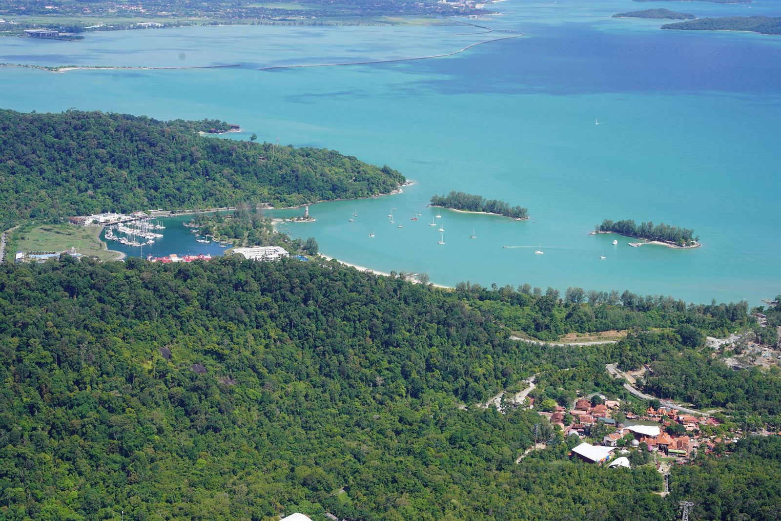 Aerial view of Langkawi's forested coastline, marina and small islands in turquoise Andaman Sea