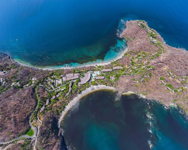 Aerial view of the Papagayo Peninsula in Guanacaste with a resort between two deep blue bays