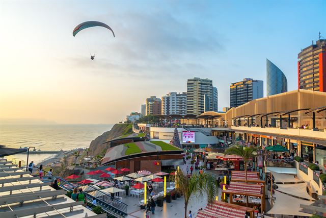 Paraglider over the Larcomar clifftop mall and Miraflores towers in Lima, Peru