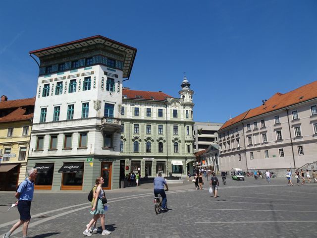 Preseren Square in Ljubljana with the ornate Urbanc House and pedestrians on the paved plaza