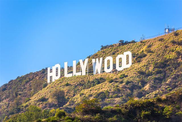 The Hollywood Sign on the dry hillside of Mount Lee under a clear blue sky