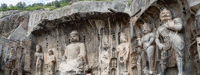 Carved Buddha and guardian statues in the Fengxiangsi cave at Longmen Grottoes, Luoyang