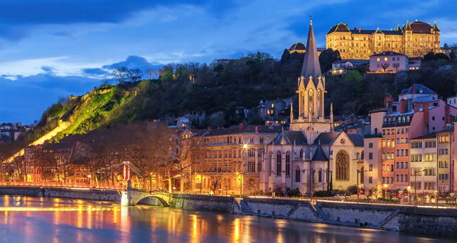 Lyon Saint-Jean Cathedral and Fourviere basilica lit at night above the Saone River