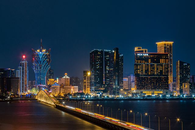 Macau skyline at night with the lotus-shaped Grand Lisboa and illuminated casino hotels across the water
