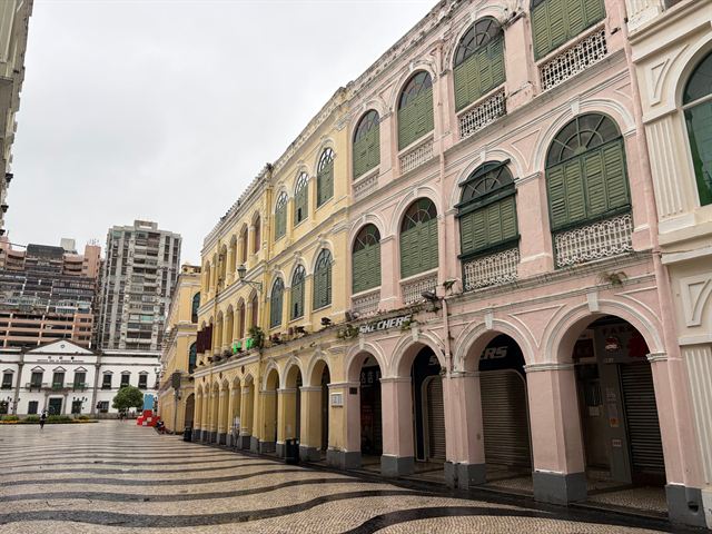 Pastel colonial arcades and wave-pattern cobbles of Senado Square in historic Macau