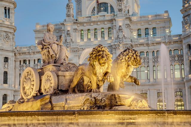 Cibeles Fountain with goddess and lions in front of the ornate Cybele Palace, Madrid