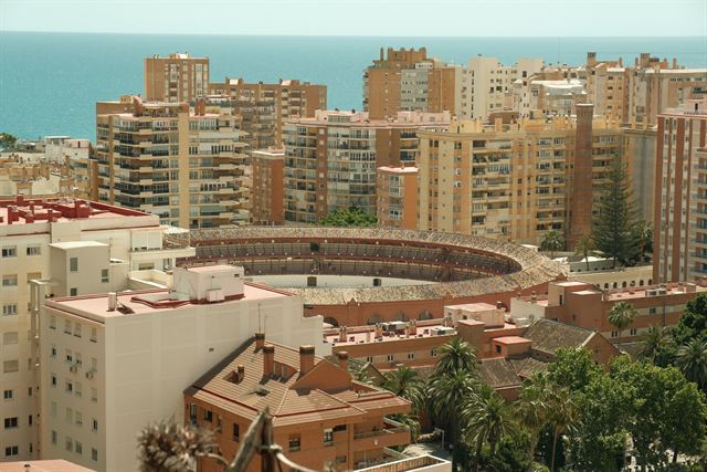La Malagueta bullring in Málaga surrounded by apartment blocks with the Mediterranean behind