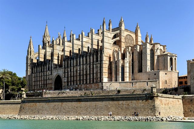 La Seu Gothic cathedral in Palma de Mallorca above the old sea walls under clear blue sky