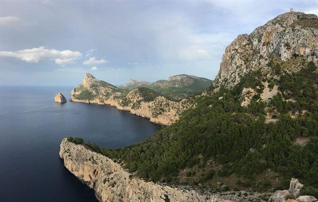 Cap de Formentor peninsula in Mallorca, rugged green cliffs dropping into the dark blue sea