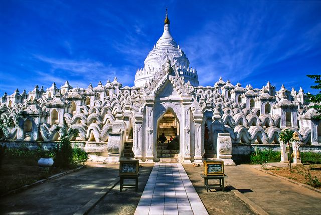 White Sandamuni Pagoda and rows of white stupas under blue sky in Mandalay