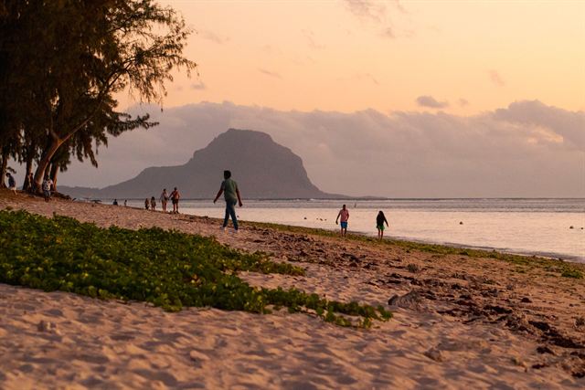 Flic en Flac beach in Mauritius at sunset with Le Morne Brabant mountain silhouetted across the bay