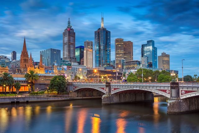 Melbourne CBD skyline at dusk over Princes Bridge and the Yarra River with St Pauls spires