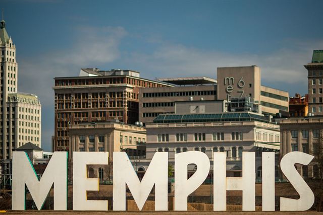 Giant white MEMPHIS letters sculpture in front of historic downtown Memphis buildings and towers