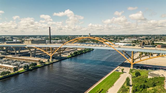 Aerial view of the yellow-arched Hoan Bridge crossing the Milwaukee River toward the city