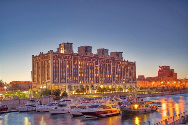 Yachts in the Old Port marina below a lit brick warehouse building, with the Molson brewery sign beyond, Montreal
