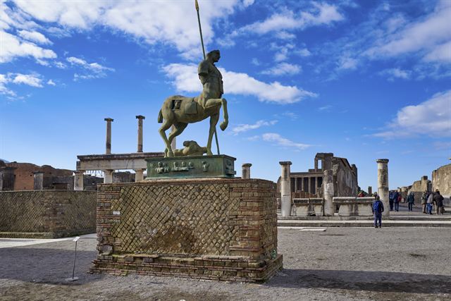 Bronze centaur sculpture among the ruins of Pompeii's Forum